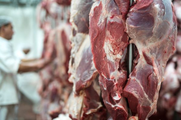 carne vermelha fresca e trabalhador de acougue trabalhando em segundo plano 1024x683