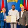 O presidente da Guiana Mohamed Irfaan Ali ladeado pelo governador Antonio Denarium e pelo secretario